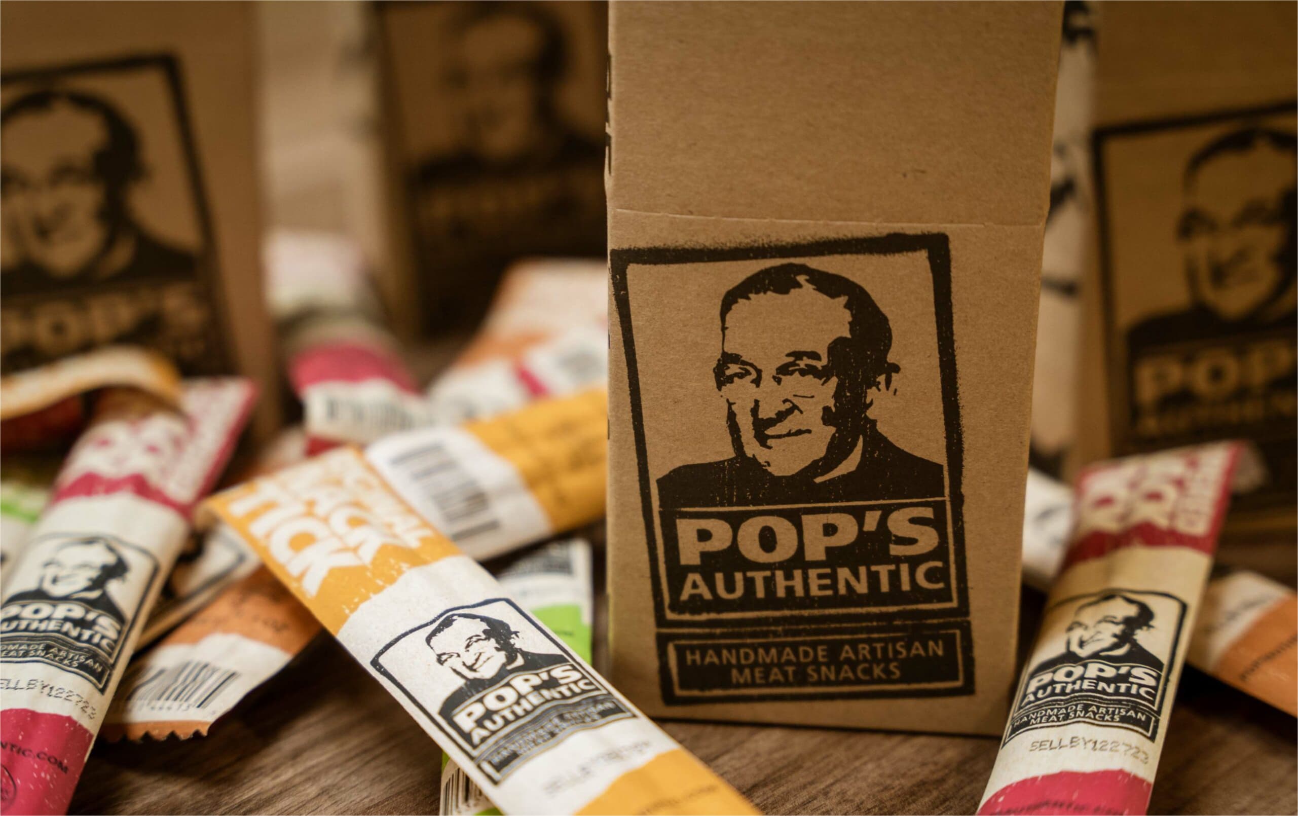 Individually wrapped snack sticks of various flavors lying on a wooden table.