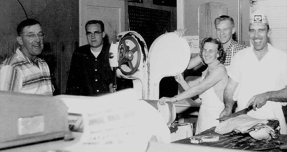 A black and white photo of the Jennings Family in the original meat shop. 